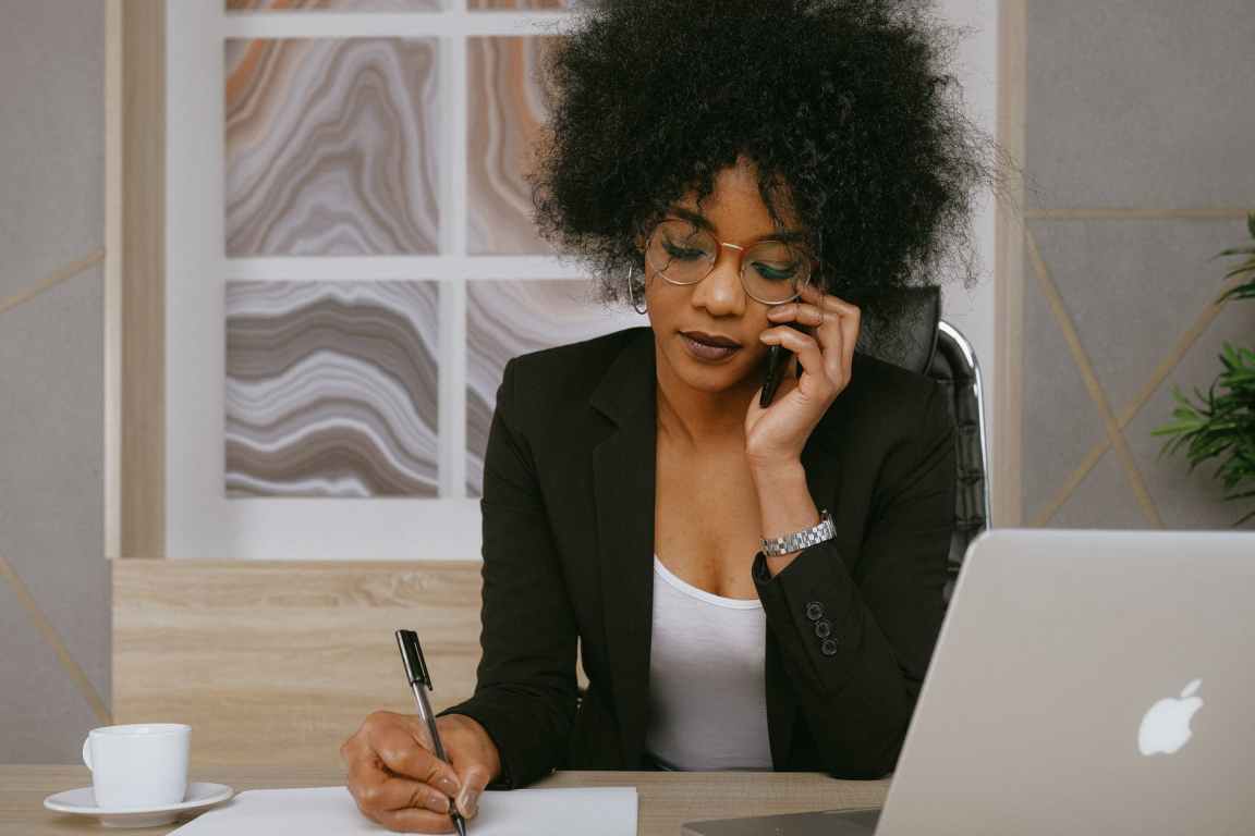 woman in black blazer holding smartphone